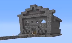 This is a screenshot of someone's minecraft stream. It is unclear who is streaming. It is a stone and stone brick building with some white windows in the shape of pluses. It is completely suspended in air and the only way to get to it is a small cobblestone path leading up to the door. A minecraft player stands in the door, but the image is too pixelated to see who it is.